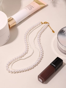 Vue détaillée d'un collier de perles à trois rangs élégant avec fermoir mousqueton doré