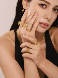 Detailed view of layered 18K gold plated U-shaped wave rings and butterfly jewelry set
