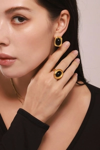 Nahaufnahme von Vintage-Goldohrringen und Ring-Set mit schwarzem Onyx an einem Modell