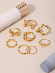 Detailed set of eight 18K gold plated PVD titanium steel rings with butterfly and heart motifs