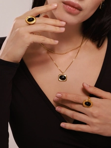 Detail von Model mit Vintage-Anhänger mit schwarzem Achat und passenden goldenen Ringen