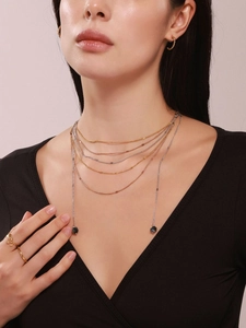 Layered gold, silver and rose gold thin necklaces with dark volcanic stone pendants