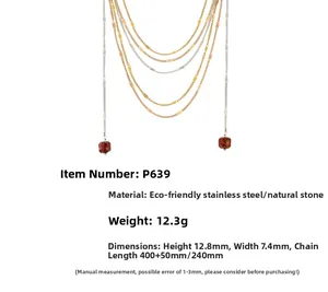 Detail of layered stainless steel necklace with red natural stone pendant and fine chains