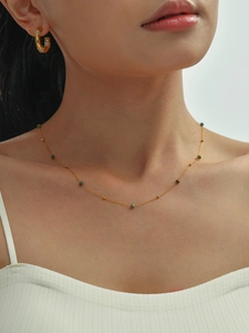 Detalle de collar de cuentas de piedra natural 2mm y pendientes de aro dorados