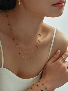 Detalle del conjunto de collar y pulsera bañados en oro de 18K con cuentas de gemas