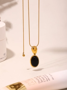 Détail d'une chaîne serpent en or 18K avec pendentif onyx noir et fermoir goutte