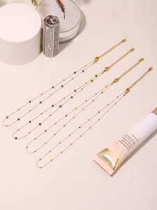 Detalle de collares de acero inoxidable bañados en oro con cuentas de piedras naturales
