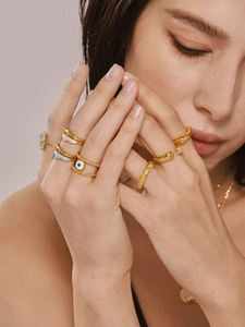 Detail of gold-plated rings with blue enamel evil eye and flowing irregular shapes