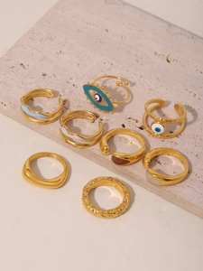 Macro shot of 8-piece gold-plated 18K ring set with blue evil eye and enamel details