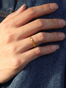 Detailed view of a slender 18K gold plated stainless steel ring with a rectangular zircon