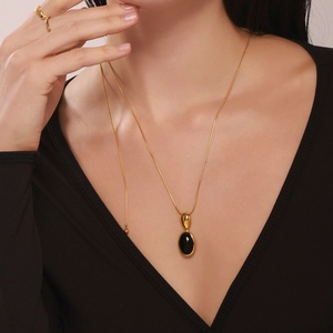 Collier ajustable style français avec pendentif onyx noir et bague assortie sur modèle