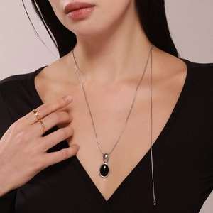 Collier avec pierre œil de tigre ovale et bagues plaquées or sur un mannequin