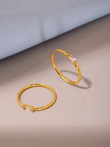 Close-up of double-layered gold rings with rectangular zircon stones in minimalist design