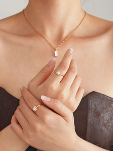 Close-up of elegant gold plated adjustable rings with round cubic zirconia on hand