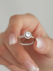 Close-up of silver ring with a sparkling 5A zircon halo and small pave-set diamonds
