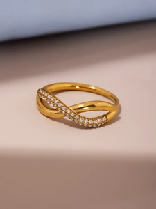 Macro detail of infinity cross ring in gold finish with micro-pave white zircon stones