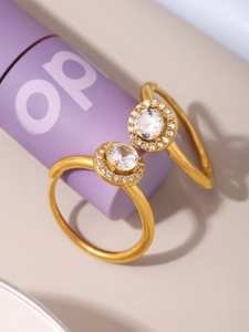 Detailed close-up of two golden halo rings with round zircon stones and a polished finish