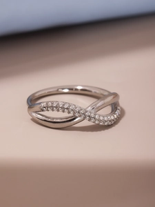 Macro view of infinity cross ring featuring micro-set sparkling white zircon stones