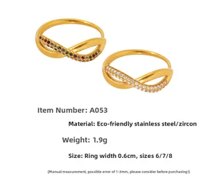 Detail of gold infinity rings with colorful and white zircons in stainless steel