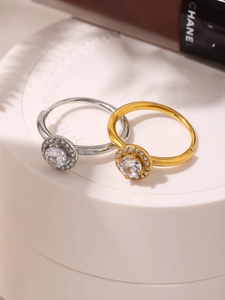Macro view of gold and silver halo rings with round cubic zirconia on a white pedestal