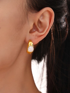 Détail macro de l'élégante boucle d'oreille créole en or 18 carats avec nacre blanche
