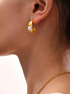 Gros plan sur les boucles d'oreilles créoles en croissant dorées à l'or 18 carats