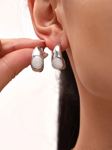Gros plan de boucles d'oreilles croissants argentés avec incrustation blanche