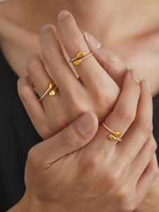 Détail d'une bague mains qui s'enlacent dorée 18 carats sertie de zircons sur mannequin