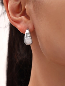 Gros plan de boucles d'oreilles en or en forme de croissant avec émail rose et perle