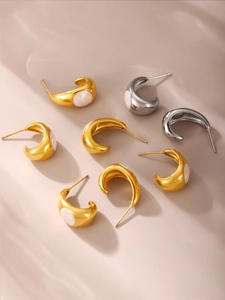 Détail de boucles d'oreilles en C avec incrustation pailletée blanche en or et argent