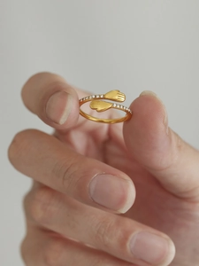 Détail macro de la bague câlin avec pierres de zircon en acier inoxydable doré