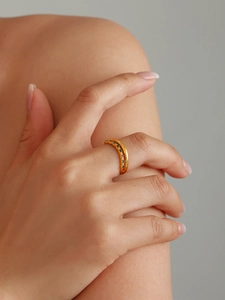 Close-up of gold double-layered ring with green zircon stones on a female hand