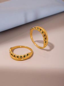 Detailed macro view of gold-plated double layer rings featuring green zircon stones