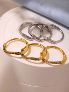 Detail van gouden en zilveren oorringen met pavé gezette kleurrijke zirkonia kristallen
