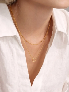 Détail du collier doré double rang orné d'un pendentif cœur serti de zircons brillants