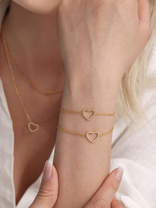 Détail de l'ensemble collier et bracelet dorés avec pendentifs en forme de cœur en zircon