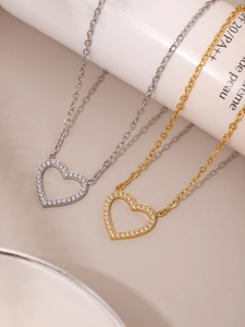 Gros plan de colliers pendentifs en forme de cœur en or et argent avec micro-zircons