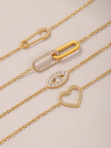 Mise à plat de quatre colliers dorés avec pendentifs épingle, anneau double et cœur