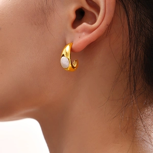 Boucles d'oreilles goutte dorées 18k avec perle en résine blanche sur mannequin
