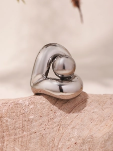 Détail macro d'une bague en argent poli sur une texture de pierre claire élégante
