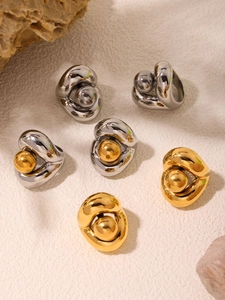 Détail de bagues abstraites à perles plaquées or 18k et argent sur fond pierre