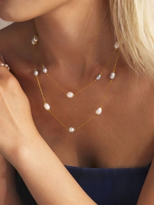 Close-up of double-layered gold chain necklace with natural freshwater pearls on model