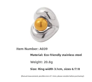 Detail of chunky two-tone stainless steel ring with gold bead and polished silver finish