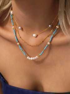 Close-up of triple-layered necklace with blue turquoise beads and freshwater pearls