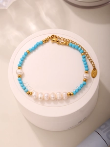 Detailed view of blue turquoise beads and freshwater pearls with gold stainless steel clasp