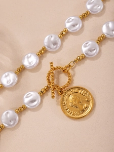 Macro shot of gold OT toggle clasp and Queen Elizabeth pendant on pearl necklace