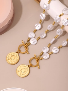 Detail of OT clasp and Queen Elizabeth II coin pendant on beaded pearl necklace