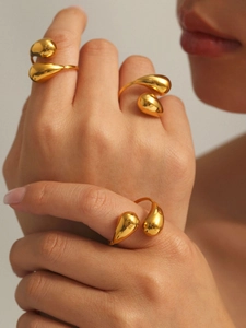 Close-up of dual hollow teardrop gold ring on finger with polished finish details