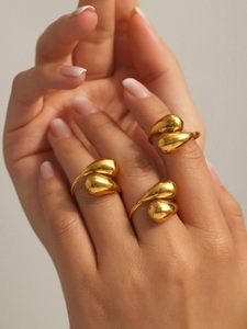 Detailed view of layered gold teardrop open rings with high-polish liquid metal finish