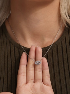 Close-up of sparkling cubic zirconia paved evil eye pendant on a silver necklace